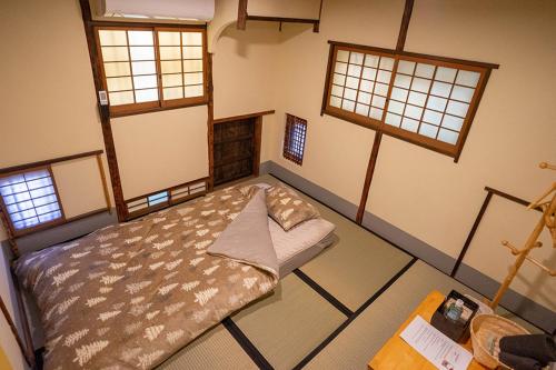 a bedroom with a bed in a room with windows at KUMANO家-OHGi- in Shingu