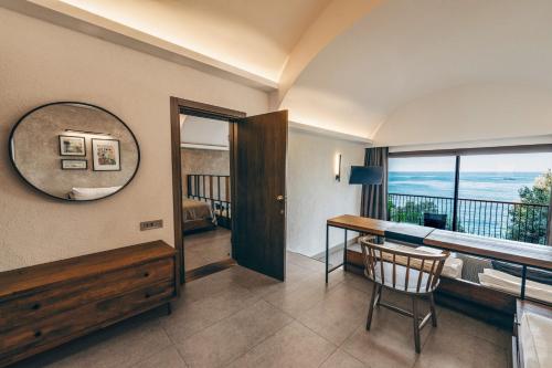 a room with a desk and a view of the ocean at Club Marvy in Ozdere