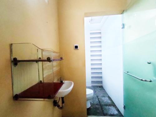 Un baño con lavabo e inodoro en una habitación. en Omah Sewu 68 By Reccoma, en Surabaya