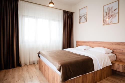 a bedroom with a large bed and a window at At George`s Stay&Fly in Otopeni