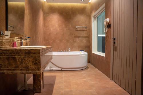 une salle de bain avec une baignoire et un lavabo dans l'établissement شاليهات ومنتجعات ارجان بارك, à Riyad