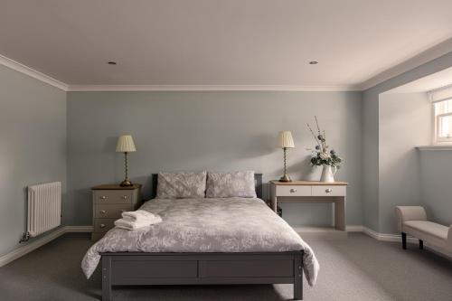 a bedroom with a bed and two tables and a chair at Elrick Estate - Little Elrick in Newmachar