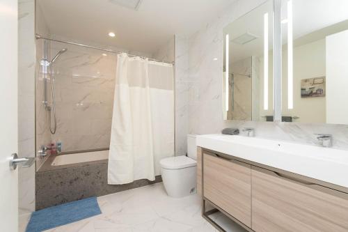 a bathroom with a sink and a toilet and a shower at Cozy 3BR High Rise with Pool with great views in Los Angeles