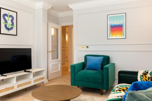 a living room with a green chair and a tv at Stay Kula London Bridge in London