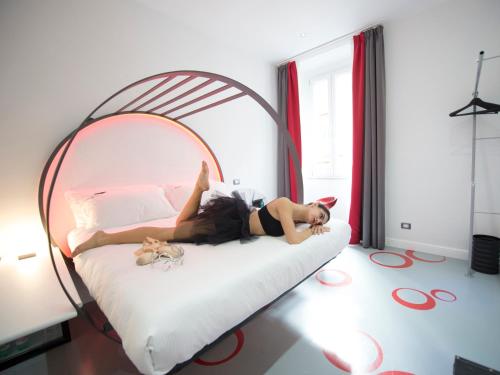 a woman laying on a bed in a bedroom at 7 Inn Spanish Steps in Rome