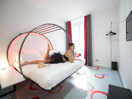 a woman laying on a bed in a room at 7 Inn Spanish Steps in Rome
