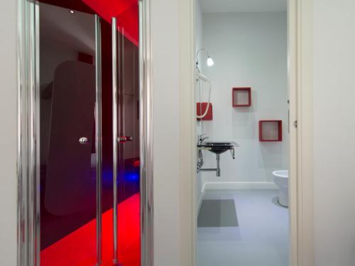 a bathroom with a shower with a red floor at 7 Inn Spanish Steps in Rome