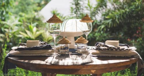 a table with wine glasses and cookies on it at Sandat Glamping Tents in Ubud