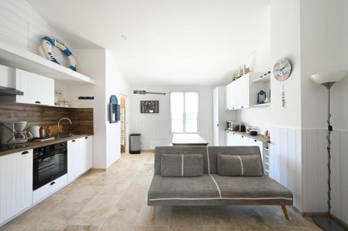 un salon avec un canapé dans une cuisine dans l'établissement 766 Amoremi - New apartment, heart of village, à Saint-Martin-de-Ré