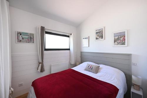 une chambre avec un lit avec une couverture rouge et une fenêtre dans l'établissement 766 Amoremi - New apartment, heart of village, à Saint-Martin-de-Ré