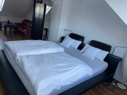 Elle comprend un grand lit avec des draps et des oreillers blancs. dans l'établissement Luxuriöses Zimmer 10min zum Universität Kassel, à Cassel