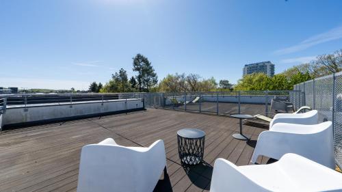 ミエンジズドロイェにあるGolden Tulip, Sun & Snowの屋上に白い椅子とテーブルが備わるデッキ