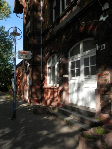 a brick building with a white door on a street at Relax Hotel-Ludwigshafen in Ludwigshafen am Rhein