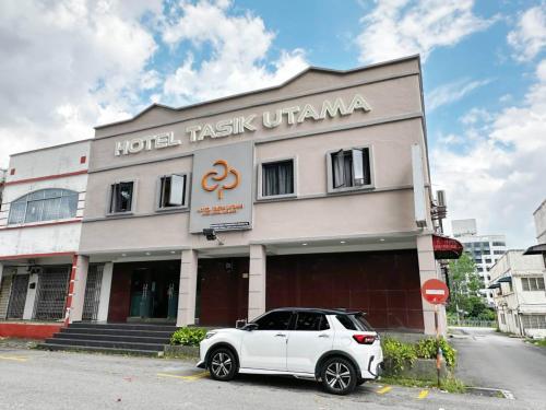 a white car parked in front of a building at Hotel O Tasik Utama in Malacca