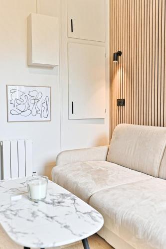 un salon avec un canapé et une table dans l'établissement Petit studio charmant près de Paris - III, à Neuilly-sur-Seine