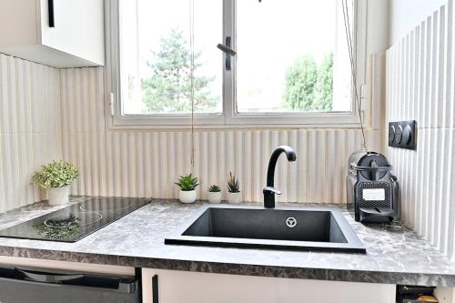 un comptoir de cuisine avec un évier dans une cuisine dans l'établissement Petit studio charmant près de Paris - III, à Neuilly-sur-Seine