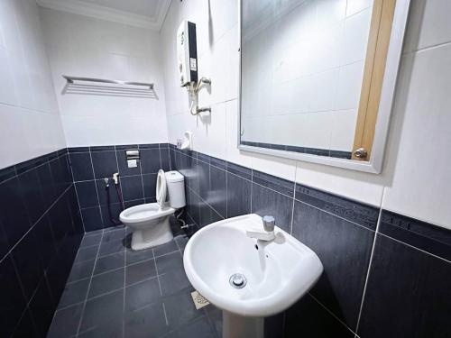 a bathroom with a sink and a toilet at Hotel O Tasik Utama in Malacca