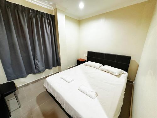 a bedroom with a bed with white sheets and a window at Hotel O Tasik Utama in Malacca