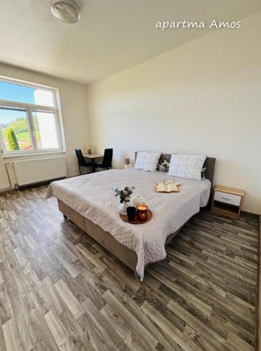 a bedroom with a bed and a table with flowers on it at Apartmány Komenského Velké Losiny in Velké Losiny