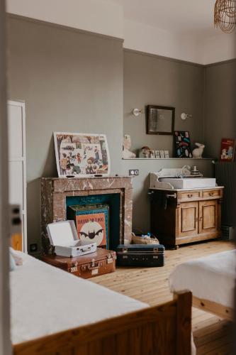 un salon avec une cheminée et un lit dans l'établissement Maison Sollier, à Sainte-Croix