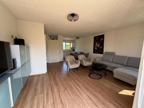 a living room with a couch and a table at Vakantiehuis Strand ,water,met infraroodsauna in Breskens