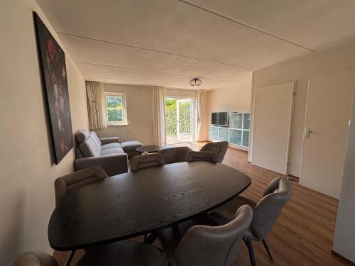 a living room with a table and chairs at Vakantiehuis Strand ,water,met infraroodsauna in Breskens