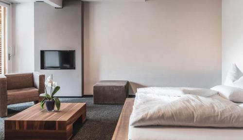 a living room with a bed and a couch and a tv at Feldmilla Design Hotel - Wellness & SPA in Campo Tures