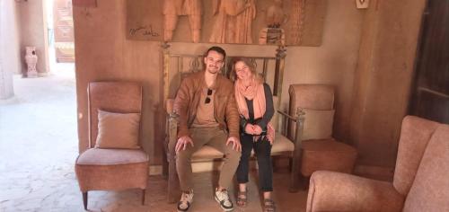 a man and a woman sitting on a bed at Qasr El Bagawat Hotel in ‘Ezbet Halfa