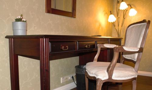 a wooden desk with a chair and a mirror at Taanilinna Hotell in Tallinn