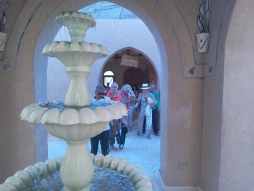 a fountain in a building with people walking down a street at Qasr El Bagawat Hotel in ‘Ezbet Halfa