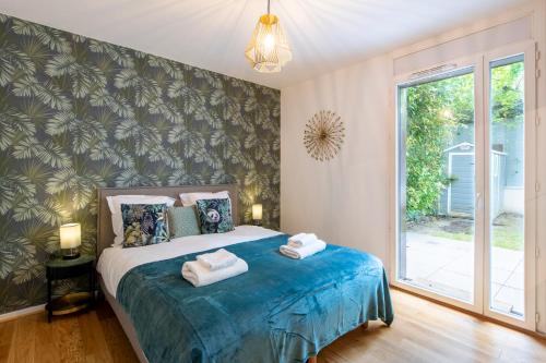 a bedroom with a bed with towels on it at Stunning 3Bedroom Apartment with Garden in Prestigious Area I Eiffel Tower Within 15 Minutes' Drive in Issy-les-Moulineaux