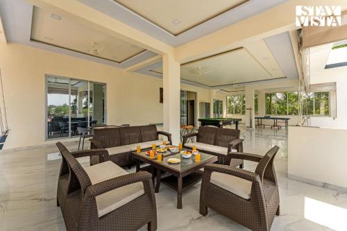 a living room with a table and chairs at StayVista at Sky Hills with BBQ, Pool in Chinchavli
