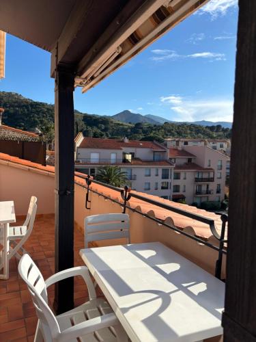 un balcon avec une table et des chaises et une vue dans l'établissement T3 dans Résidence avec Parking et Piscine, situé au 3ème étage, à Collioure