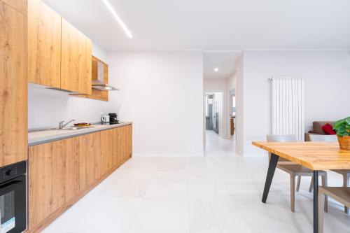 a kitchen with wooden cabinets and a wooden table at Borgo Trento Residence in Verona