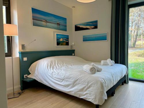 une chambre avec un lit avec des serviettes dessus dans l'établissement Villa Greensome sur le Golf de Saint-Émilion, à Gardegan-et-Tourtirac