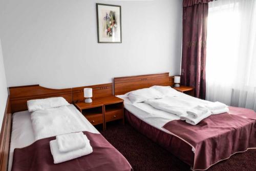 two beds in a hotel room with towels on them at Hotel Złoty Młyn Polichno in Polichno