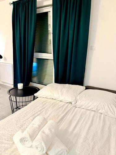 a bedroom with a bed with a green curtain at LOFT APARTAMENT I Kępno in Kępno