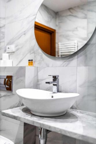 a bathroom with a white sink and a mirror at Hotel Złoty Młyn Polichno in Polichno
