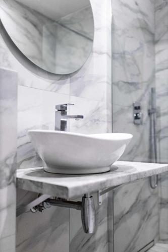 a bathroom with a white sink and a mirror at Hotel Złoty Młyn Polichno in Polichno