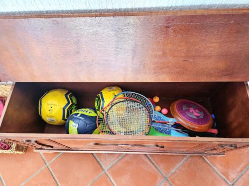 a wooden box filled with tennis balls and tennis rackets at Villa EMI in Zgornje Škofije