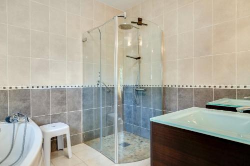 a bathroom with a shower and a tub and a sink at Maison La Joye Sud in Saint-André-de-Cubzac