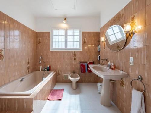 a bathroom with a tub and a sink and a toilet at Maison des Artistes - Centre Ville in Narbonne