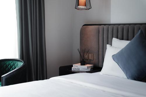 a bedroom with a bed and a nightstand with a clock on it at 22Land Cloud Hotel Hanoi in Hanoi