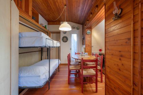 Habitación con literas, mesa y comedor. en Wonderful Mountains View, en Ponte di Legno