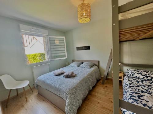 une chambre avec un lit, une chaise et une fenêtre dans l'établissement Le Calme Marin avec jardin à 150m de la plage, à Courseulles-sur-Mer