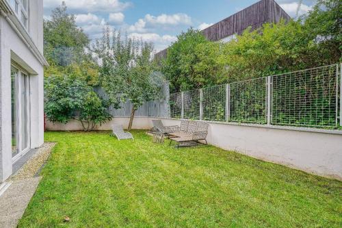 a yard with two benches and a fence at Stunning 3Bedroom Apartment with Garden in Prestigious Area I Eiffel Tower Within 15 Minutes' Drive in Issy-les-Moulineaux