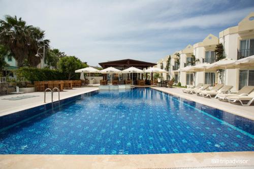 - une piscine avec des chaises et des parasols à côté d'un bâtiment dans l'établissement Viras Hotel, à Ortakent