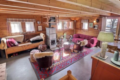 a living room with a couch and a fireplace at Grange de Fonville - Evolène - Valais in Evolène
