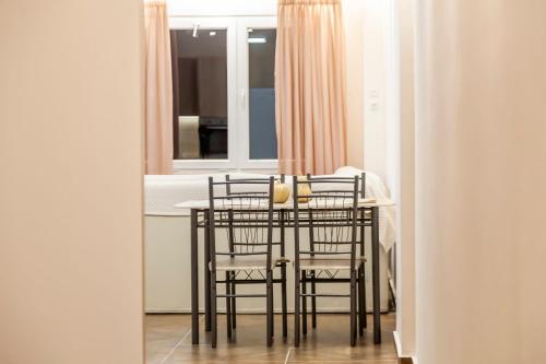 a dining room table with chairs and a window at Ioannina Central Apartment by SuperhostHub in Ioannina