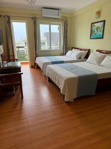 a hotel room with two beds and a piano at Minh Khang Hotel Cửa Lò in Cửa Lò
